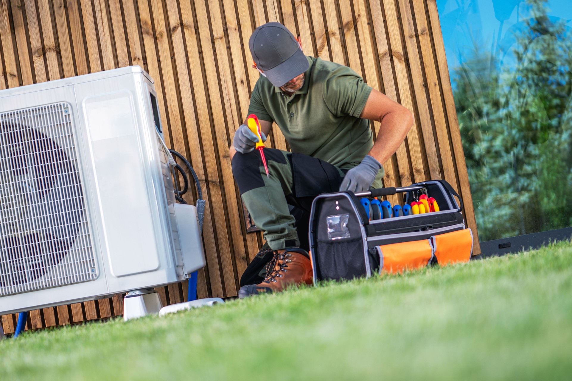HVAC Technician Working on Air Conditioning Unit Outdoors on a Sunny Day